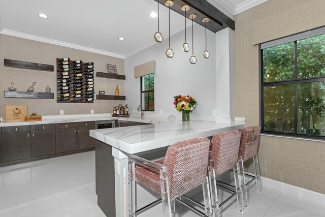 kitchen featuring decorative light fixtures, a kitchen breakfast bar, kitchen peninsula, light stone countertops, and dark brown cabinets