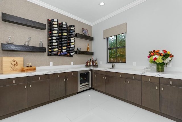 bar featuring crown molding, beverage cooler, light stone counters, and dark brown cabinets