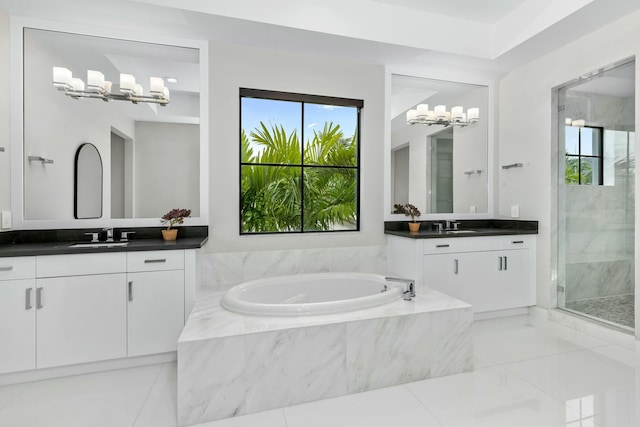 bathroom featuring a healthy amount of sunlight, independent shower and bath, and vanity