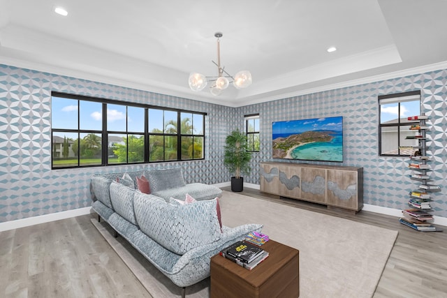 living room with a tray ceiling, a wealth of natural light, ornamental molding, and hardwood / wood-style flooring