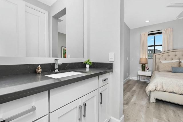 bedroom with sink and light hardwood / wood-style flooring