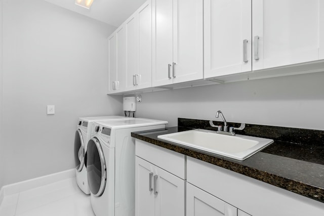 clothes washing area with tile patterned flooring, sink, washer and clothes dryer, and cabinets