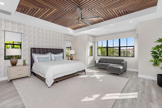 bedroom with a tray ceiling, light hardwood / wood-style flooring, and wooden ceiling