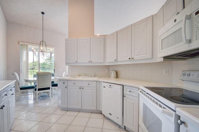 kitchen featuring white cabinets, a textured ceiling, white appliances, and hanging light fixtures