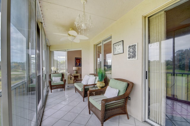 sunroom / solarium with ceiling fan with notable chandelier