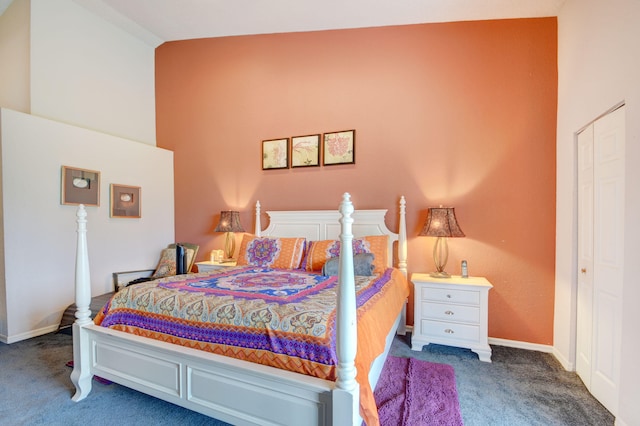 bedroom with dark colored carpet, a closet, and vaulted ceiling