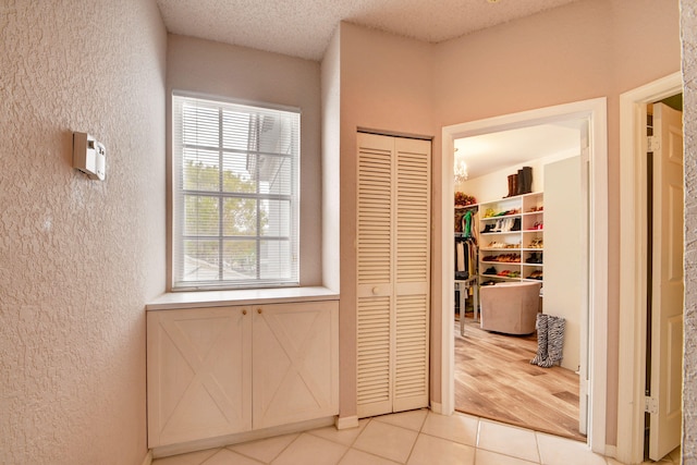 corridor featuring light hardwood / wood-style flooring and a textured ceiling