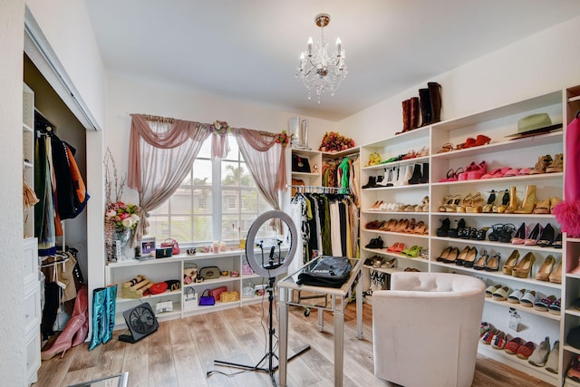 walk in closet featuring a chandelier and light hardwood / wood-style floors