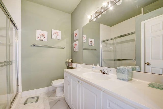 bathroom featuring toilet, vanity, tile patterned floors, and an enclosed shower