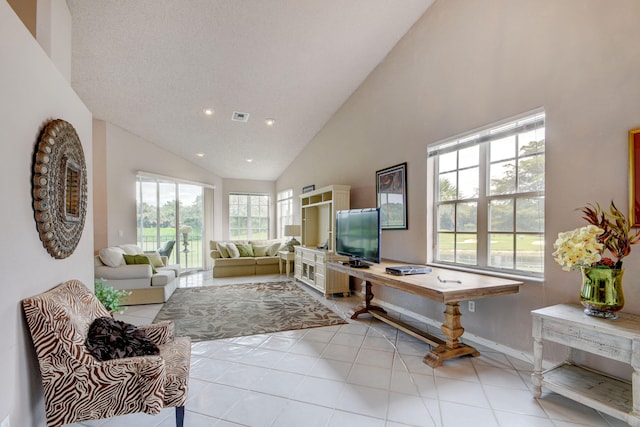 tiled living room with a textured ceiling and high vaulted ceiling