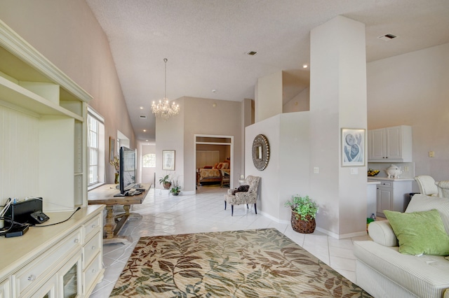 interior space featuring light tile patterned floors, a textured ceiling, high vaulted ceiling, and an inviting chandelier