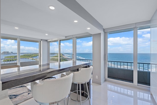 sunroom featuring a water view