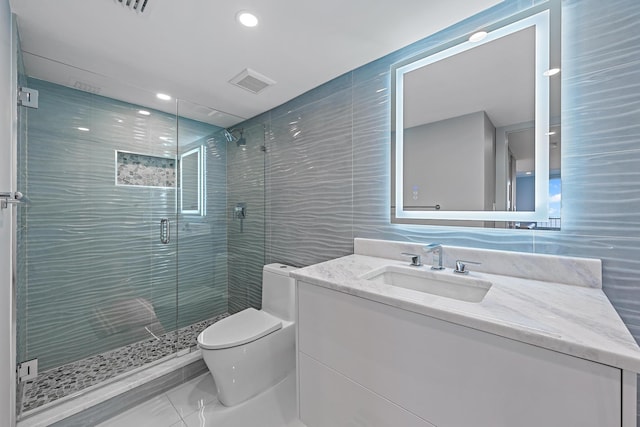 bathroom with an enclosed shower, vanity, toilet, and tile walls