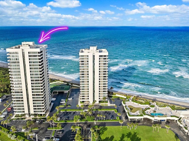 birds eye view of property with a water view and a beach view