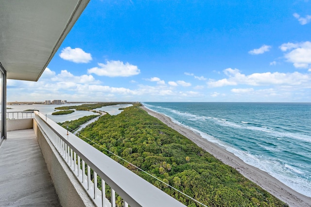 balcony with a water view and a view of the beach