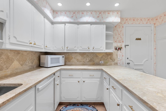 kitchen featuring backsplash, light tile patterned floors, white cabinets, and white appliances