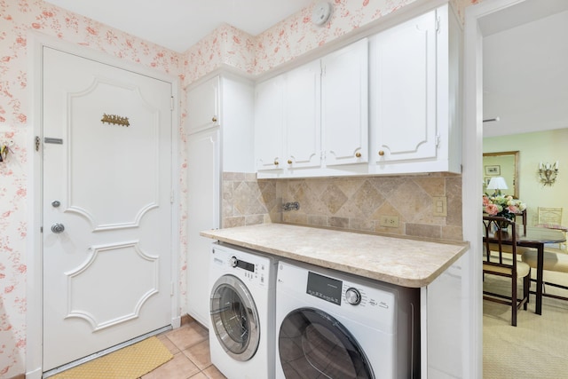 washroom with cabinets, separate washer and dryer, and light tile patterned floors