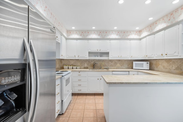 kitchen featuring sink, stainless steel appliances, white cabinets, backsplash, and light tile patterned flooring