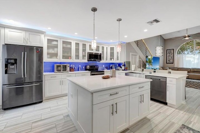 kitchen with kitchen peninsula, stainless steel appliances, and white cabinetry