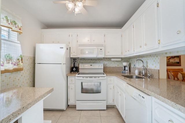 kitchen with white cabinetry, sink, light stone countertops, and white appliances