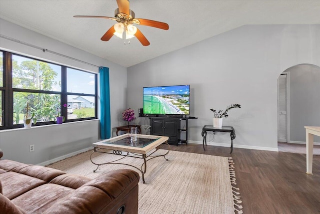 living room featuring ceiling fan, dark wood-type flooring, and vaulted ceiling