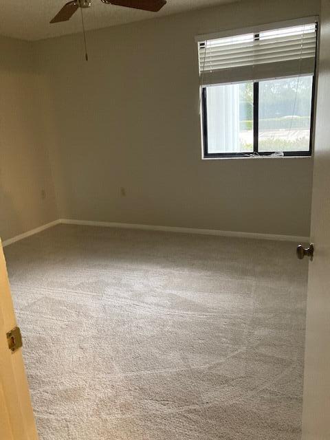 unfurnished room with carpet floors and ceiling fan