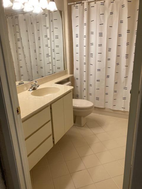 bathroom with toilet, a shower with curtain, vanity, and tile patterned floors