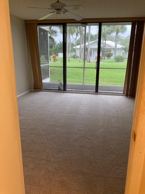 carpeted spare room featuring ceiling fan