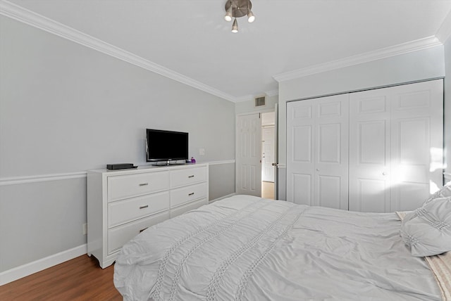 bedroom with a closet, ornamental molding, and hardwood / wood-style flooring