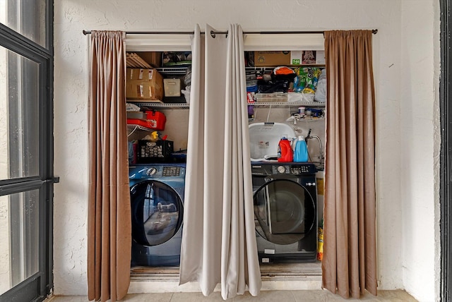 laundry area with washer / dryer and light tile patterned floors