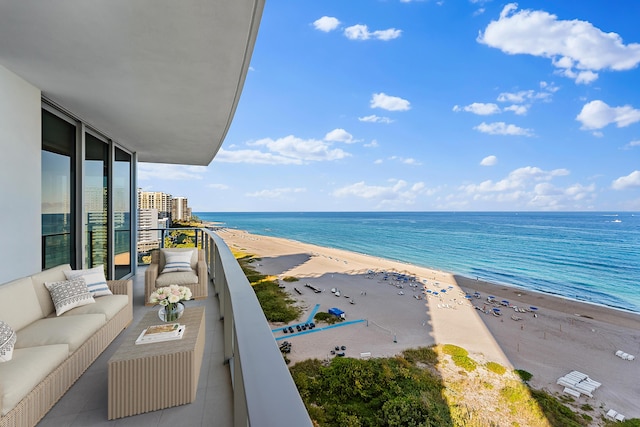 balcony featuring a water view, a beach view, and an outdoor hangout area