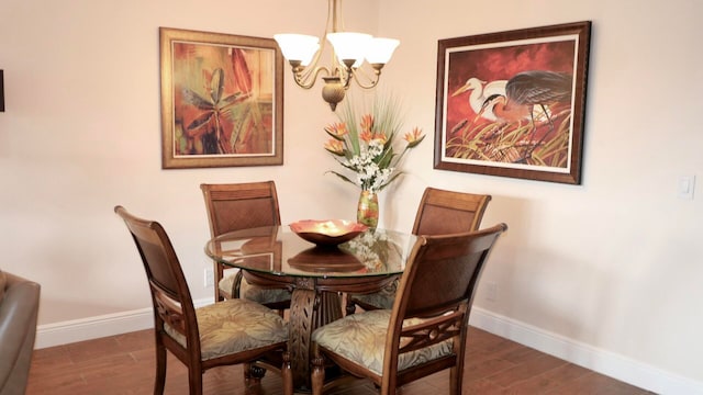 dining area with hardwood / wood-style flooring and a chandelier