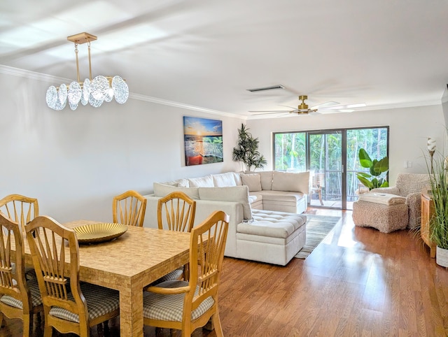 dining area featuring ceiling fan with notable chandelier, light hardwood / wood-style floors, and crown molding