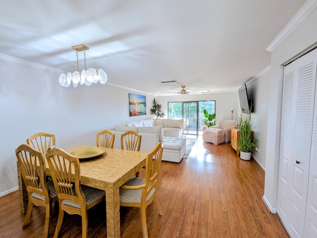 dining space with hardwood / wood-style flooring, ceiling fan, and ornamental molding