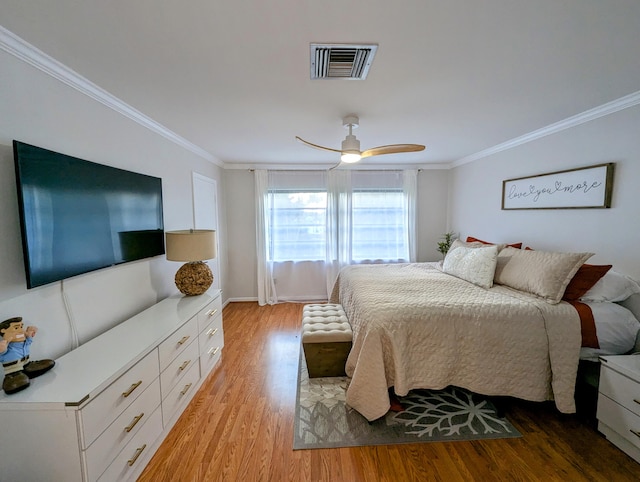 bedroom featuring ceiling fan, crown molding, and light wood-type flooring