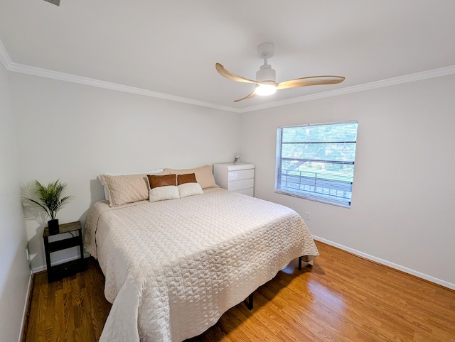 bedroom featuring ceiling fan, crown molding, and hardwood / wood-style flooring