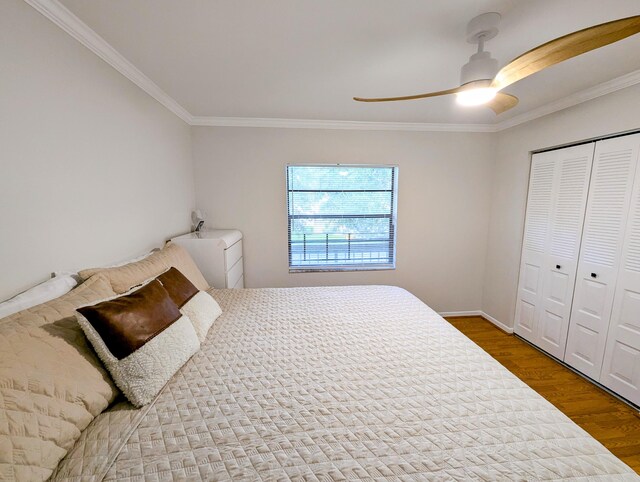 bedroom with hardwood / wood-style floors, a closet, ceiling fan, and crown molding