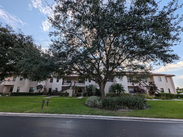 view of property hidden behind natural elements with a front yard