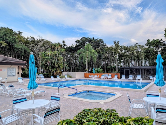 view of swimming pool featuring a community hot tub and a patio