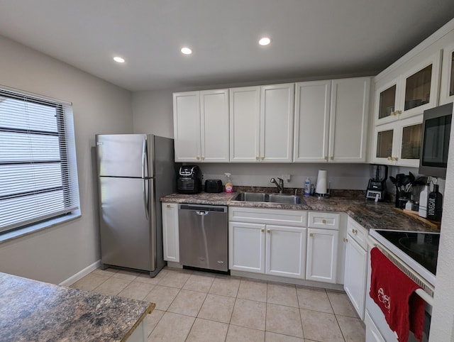 kitchen featuring light tile patterned flooring, appliances with stainless steel finishes, white cabinetry, and sink