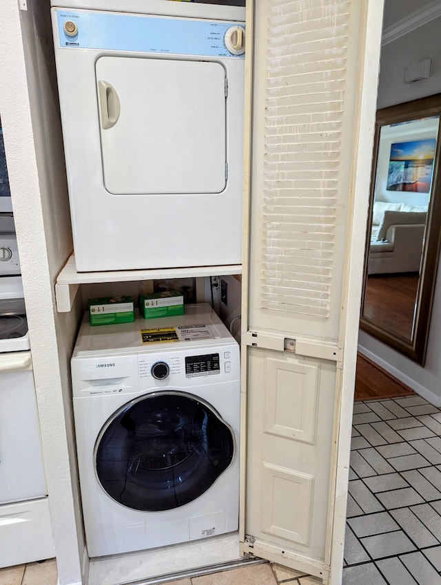 laundry area featuring light tile patterned floors and stacked washer / dryer