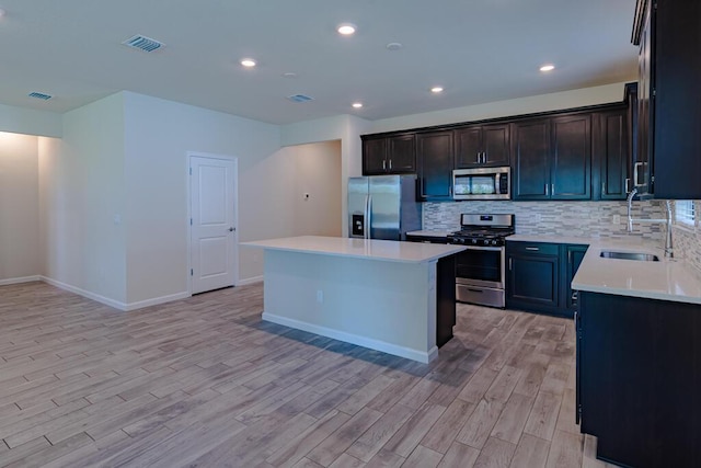 kitchen featuring tasteful backsplash, visible vents, appliances with stainless steel finishes, light countertops, and a sink