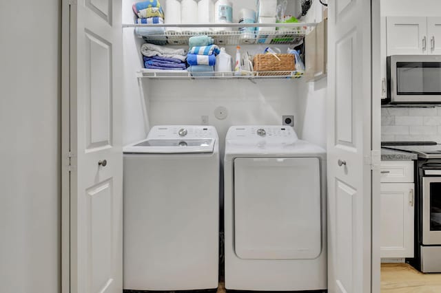 washroom with light hardwood / wood-style flooring and washer and dryer