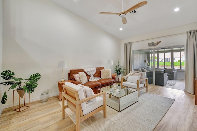 living room featuring ceiling fan, light hardwood / wood-style floors, and vaulted ceiling