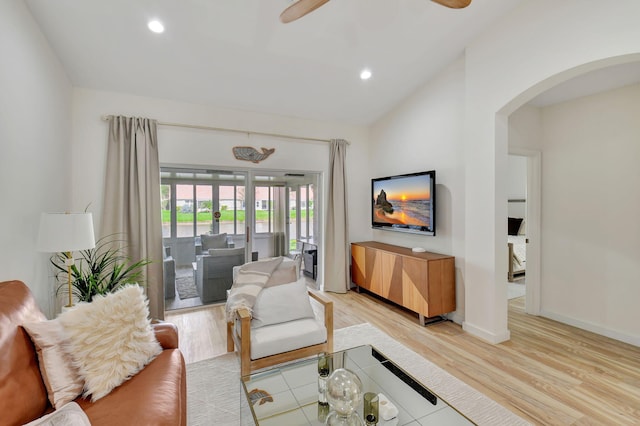 living room featuring ceiling fan, light hardwood / wood-style floors, and lofted ceiling