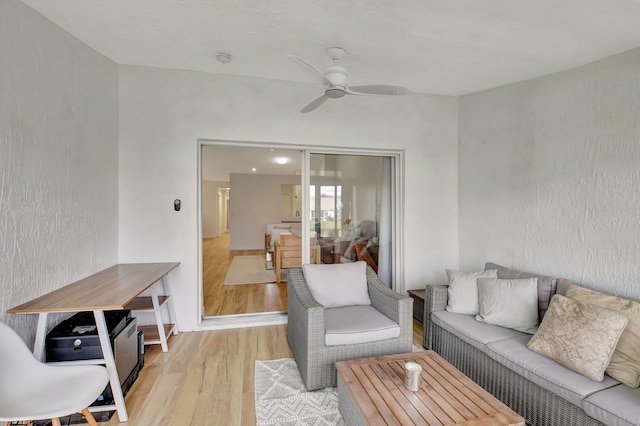 living room featuring ceiling fan and light hardwood / wood-style flooring