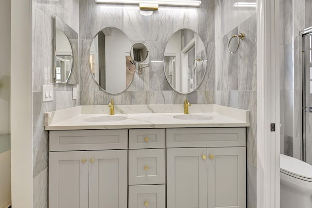 bathroom with vanity, toilet, and tile walls