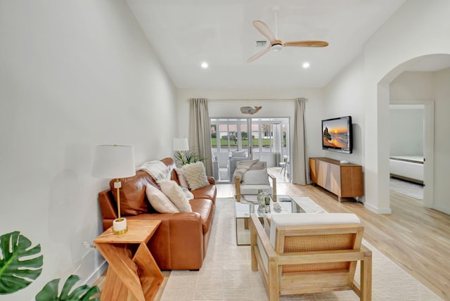 living room featuring light hardwood / wood-style flooring, ceiling fan, and lofted ceiling