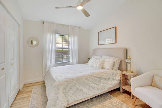 bedroom featuring ceiling fan, lofted ceiling, light hardwood / wood-style flooring, and a closet