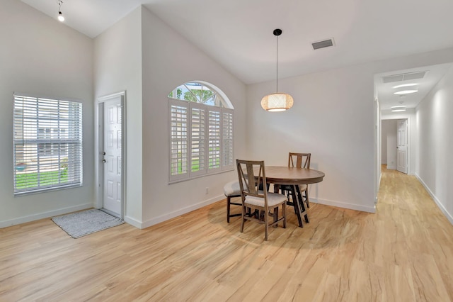 dining area with a high ceiling and light wood-type flooring